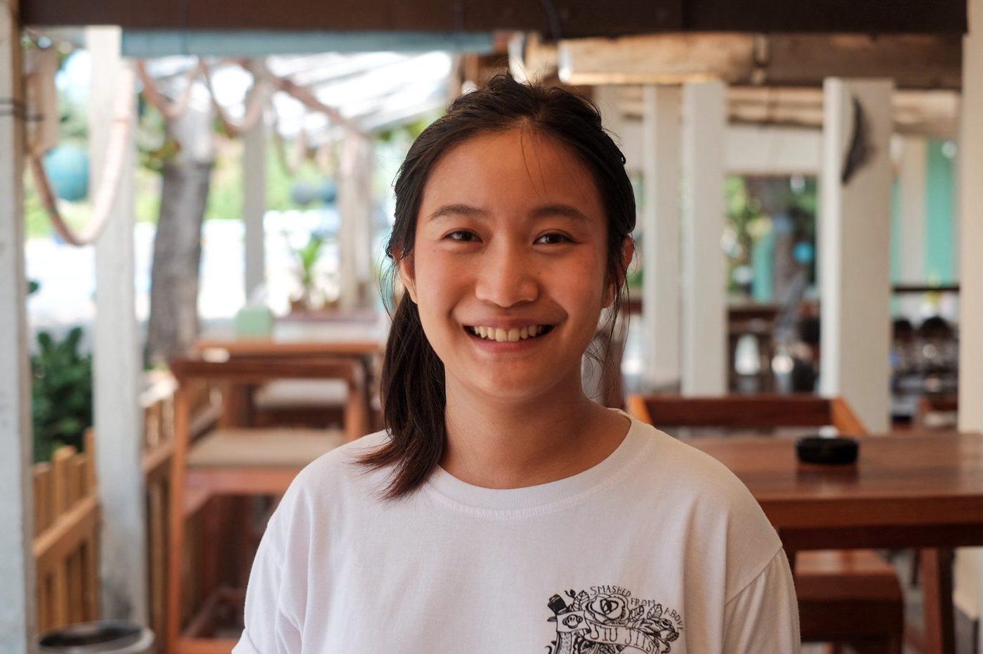 Psy at Stay Cafe on Mae Ram Phueng beach in Rayong, Thailand — behind the counter before the morning rush.