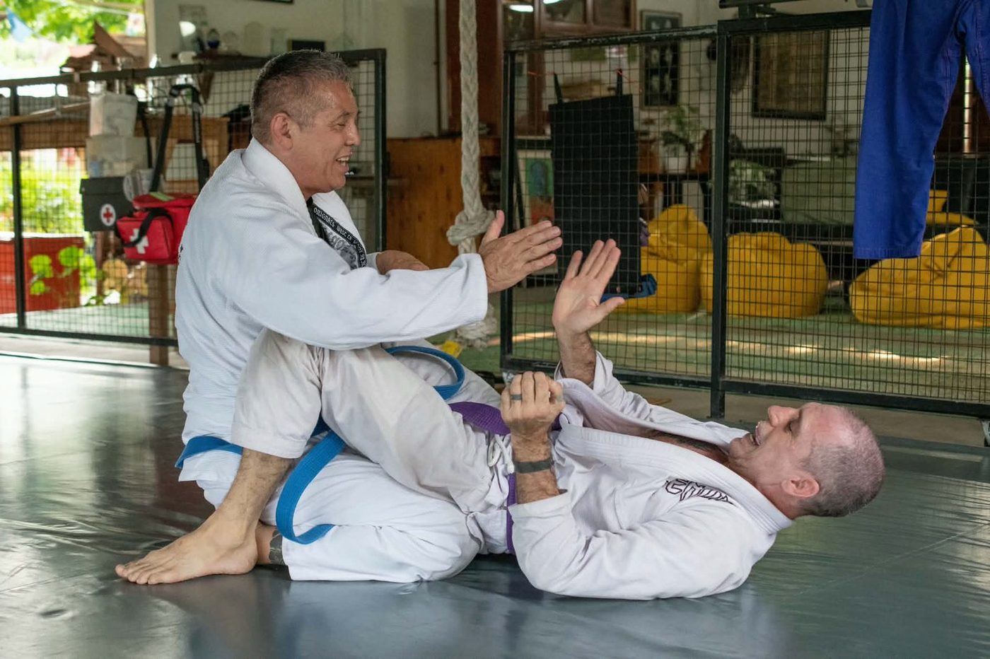Michael rolling on the mat with a training partner at Tree Roots Retreat.