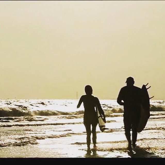 Surfers at sunset on Mae Ram Phueng Beach, Rayong